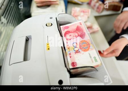 ---- Eine chinesische Angestellte verwendet eine Cash - Zählmaschine RMB (Renminbi) Yuan Banknoten bei einer Bank in Lanzhou Stadt zu zählen, der East China Jiangsu provin Stockfoto