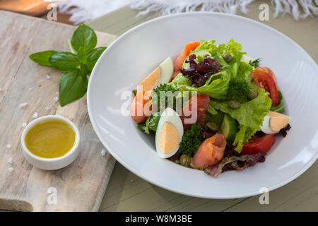 Salat mit Ei und Lachs mit Basilikum Sauce serviert und Nachfüllen Stockfoto