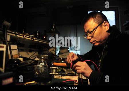 Chinesische Reparatur veteran Zhan Chunming Reparaturen eine Kamera in seinem Geschäft in Peking, China, 10. Januar 2016. Zhan Chunming hat eine Kamera Werkstatt Witz laufen Stockfoto