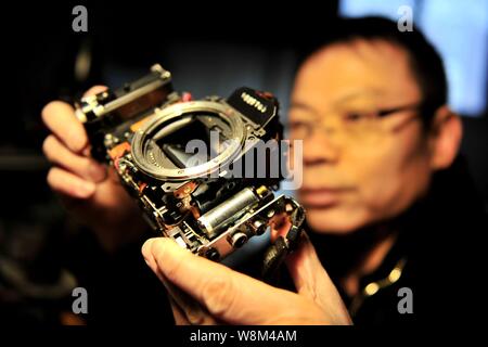 Chinesische Reparatur veteran Zhan Chunming Reparaturen eine Kamera in seinem Geschäft in Peking, China, 10. Januar 2016. Zhan Chunming hat eine Kamera Werkstatt Witz laufen Stockfoto