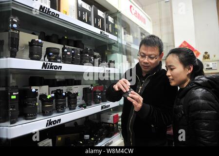 Chinesische Reparatur veteran Zhan Chunming, Links, stellt Objektiv an einen Kunden in seinem Geschäft in Peking, China, 10. Januar 2016. Zhan Chunming hat einen ca Stockfoto