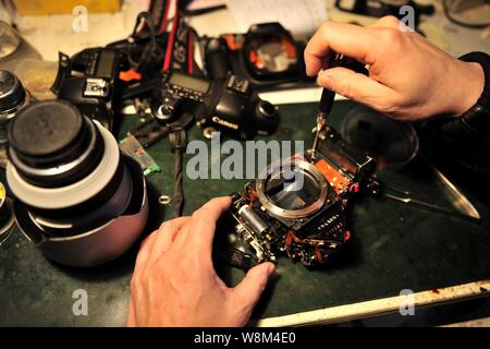 Chinesische Reparatur veteran Zhan Chunming Reparaturen eine Kamera in seinem Geschäft in Peking, China, 10. Januar 2016. Zhan Chunming hat eine Kamera Werkstatt Witz laufen Stockfoto