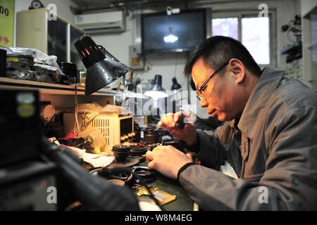 Chinesische Reparatur veteran Zhan Chunming Reparaturen eine Kamera in seinem Geschäft in Peking, China, 10. Januar 2016. Zhan Chunming hat eine Kamera Werkstatt Witz laufen Stockfoto