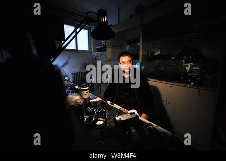 Chinesische Reparatur veteran Zhan Chunming wird dargestellt in seinem Geschäft in Peking, China, 10. Januar 2016. Zhan Chunming hat eine Kamera Reparatur Shop mit seinem Lauf Stockfoto