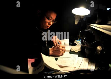 Chinesische Reparatur veteran Zhan Chunming Studien kamera Zeichnungen in seinem Geschäft in Peking, China, 10. Januar 2016. Zhan Chunming hat eine Kamera reparieren s ausführen Stockfoto