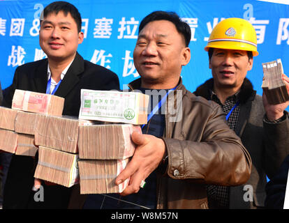 Chinesische Wanderarbeiter zeigen Bundles der Gehälter auf der Baustelle eines Immobilienprojektes in Luoyang City, Central China Provinz Henan, 9. Stockfoto