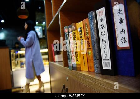 Einige traditionelle chinesische Medizin Bücher sind an ein Café namens 'KRÄUTER EXPRESSO', die von der Traditionellen Chinesischen Medizin store Huqingyutang in Hangzh angezeigt Stockfoto