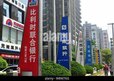 ---- Fußgänger vorbei an Schildern von chinesischen und ausländischen Banken und anderen Finanzinstituten in der Lujiazui Finanzviertel in Pudong, S Stockfoto