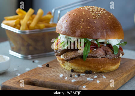 Highigh Burger mit Pommes frites in small fry Warenkorb auf Betonflächen. Traditionelle amerikanische Fastfood. Stockfoto