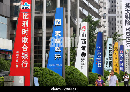 ---- Fußgänger vorbei an Schildern von chinesischen und ausländischen Banken und anderen Finanzinstituten in der Lujiazui Finanzviertel in Pudong, S Stockfoto