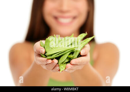 Frau mit frischen asiatischen Schnee Erbsen in Händen closeup auf weißem Hintergrund. Frau, Handvoll Erbsen pods mangetout in der hohlen Hand. Gemüse gesunde Ernährung Konzept. Stockfoto