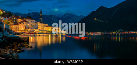 Lange Belichtung Sonnenuntergang Panoramaaussicht auf die Bucht von Kotor und Lichter in der Postkarte perfekte Stadt Perast, Montenegro mit Bergen im Hintergrund Stockfoto