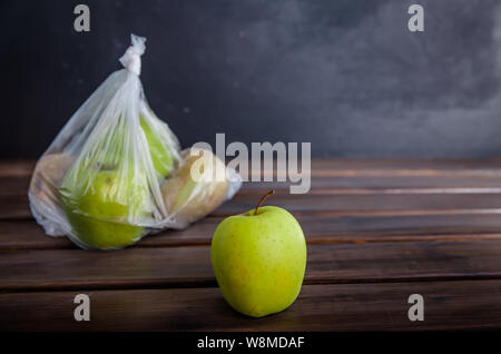 Konzept Kunststoff kostenloses Obst in einer Plastiktüte auf braunem Hintergrund mit Kopie Raum Stockfoto