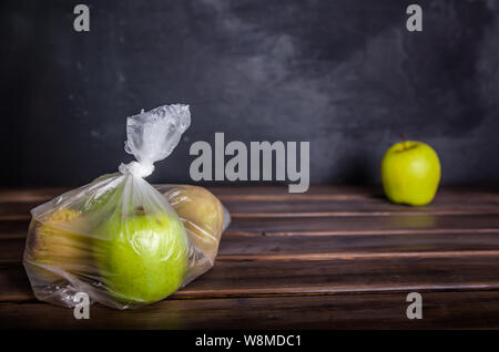 Konzept Kunststoff kostenloses Obst in einer Plastiktüte auf braunem Hintergrund mit Kopie Raum Stockfoto