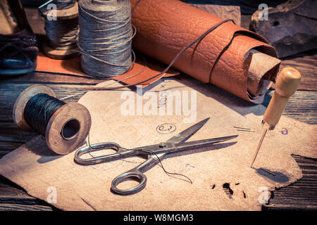 Nahaufnahme von Vintage Schuster Arbeitsplatz mit Schuhen, Schnürsenkel und Tools Stockfoto