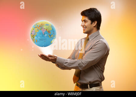 Geschäftsmann mit einer leuchtenden Welt Stockfoto