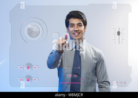 Geschäftsmann, der einen mp3-Player auf einem Touchscreen hört Stockfoto