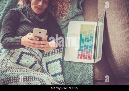 Die Technologie Menschen zu Hause - glückliche Frau mit Mobiltelefon und Tablet Computer Verlegung auf dem Sofa beim Schreiben und geben Sie am Gerät - Alternative nicht Stockfoto