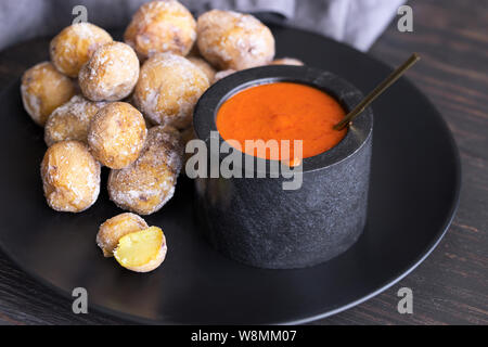 Berühmten Kanarischen Inseln Teller, Papas Arrugadas (Wrinkly Kartoffeln mit Salz) und Mojo Picon (rote Soße) auf Holz Tisch Stockfoto