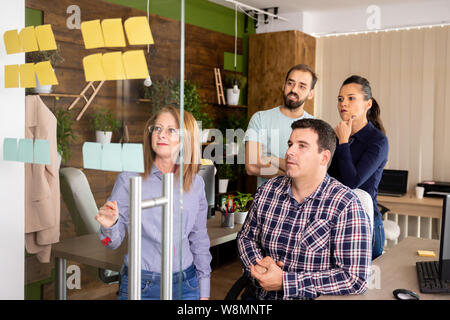 Vier Kollegen einige Daten aus der Projectin das moderne Büro besprechen Stockfoto