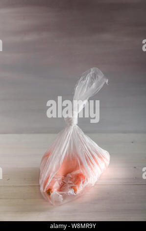 Konzept Kunststoff sich Karotten in einer Plastiktüte auf weißem Hintergrund mit Kopie Raum Stockfoto