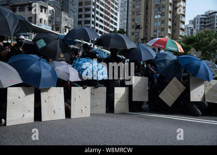 Hong Kong, New Territories, Hong Kong. 27. Juli, 2019. Demonstranten nehmen Deckung hinter Sonnenschirme bei den Auseinandersetzungen. Protesters clash heftig mit der Polizei als mehrere Runden Tränengas sind entlang der Autobahn verwendet. Die Demonstranten sind in den Straßen kämpfen für Ihre ''5'' der Regierung von Hongkong, mit die wichtigste Forderung, die vollständige Rücknahme der umstrittenen Auslieferung Rechnung. Weitere Forderungen sind eine unabhängige Untersuchung der Polizei und der Rücktritt von Carrie Lam, Hong Kong's Chief Executive. Credit: Aidan Marzo/SOPA Images/ZUMA Draht/Alamy leben Nachrichten Stockfoto