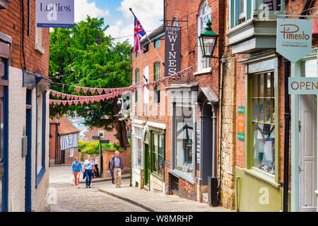 2 Juli 2019: Lincoln, Großbritannien - steile Hügel, berühmte historische Straße der Stadt, mit unabhängigen Geschäften, Cafés und Touristen zu Fuß den Berg hinauf. Stockfoto