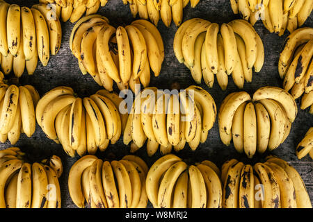 Trauben von reifen Bananen auf thailändischen Markt abgewürgt. Ansicht von oben Obst Hintergrund Stockfoto
