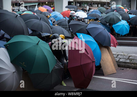 Hong Kong, New Territories, Hong Kong. 27. Juli, 2019. Demonstranten nehmen Deckung hinter Sonnenschirme bei den Auseinandersetzungen. Protesters clash heftig mit der Polizei als mehrere Runden Tränengas sind entlang der Autobahn verwendet. Die Demonstranten sind in den Straßen kämpfen für Ihre ''5'' der Regierung von Hongkong, mit die wichtigste Forderung, die vollständige Rücknahme der umstrittenen Auslieferung Rechnung. Weitere Forderungen sind eine unabhängige Untersuchung der Polizei und der Rücktritt von Carrie Lam, Hong Kong's Chief Executive. Credit: Aidan Marzo/SOPA Images/ZUMA Draht/Alamy leben Nachrichten Stockfoto