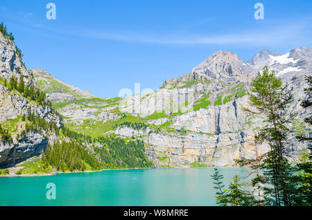 Schöne Oeschinensee Oeschinensee, fotografiert in der Schweiz an einem sonnigen Tag. Türkis See mit Rocky Mountains im Hintergrund. Alpine Landschaft Stockfoto