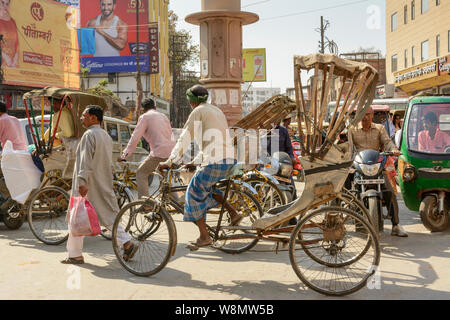 Eine Rikscha Fahrer webt, seinen Weg durch den Verkehr auf den geschäftigen Straßen von Varanasi, Uttar Pradesh, Indien, Südasien. Stockfoto