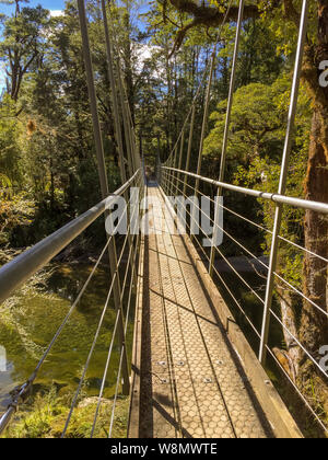 Eine schmale suspension Fußgängerbrücke erstreckt sich über einen Fluss in Neuseeland niemand im Bild Stockfoto