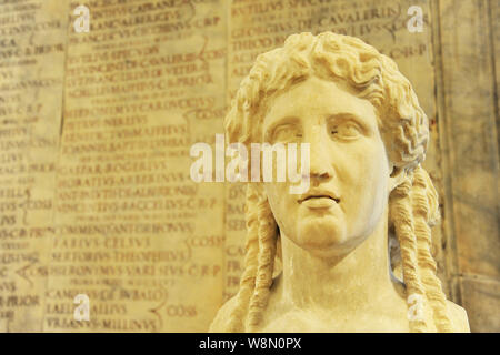 Herm von Apollo. Auf Hintergrund einige antike römische Inschrift verwischt. Rom Italien Stockfoto