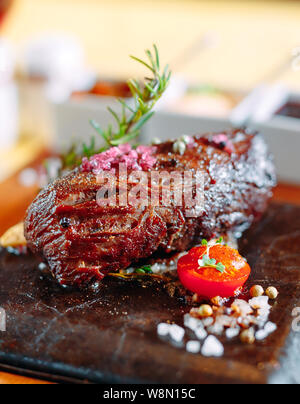 Das Essen im Restaurant. Schweinefleisch vom Grill Teller mit frischem Gemüse. Medaillons mit Kräutern und Gewürzen. Stockfoto