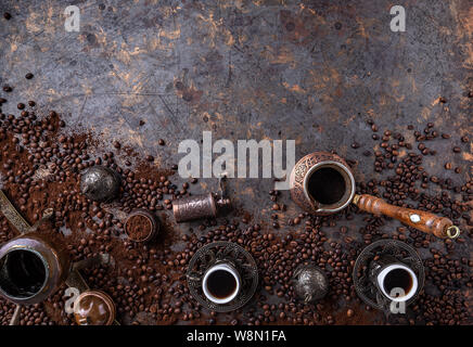 Kupfer Kaffeekanne (CEZVE), vintage Kaffeemühle, Tassen und Kaffeebohnen auf einem dunklen vintage Hintergrund Stockfoto