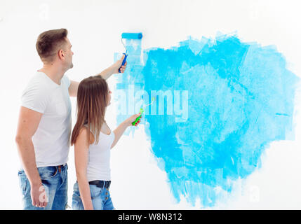 Glückliches Paar Malerei Wände in Ihrem neuen Haus bereit für zusammen leben. Stockfoto