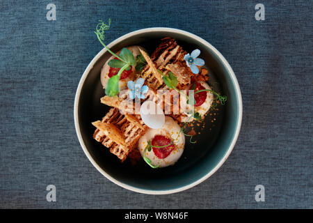 Honig Kuchen mit essbaren Blüten von oben geschossen auf Tisch im Restaurant eingerichtet Stockfoto