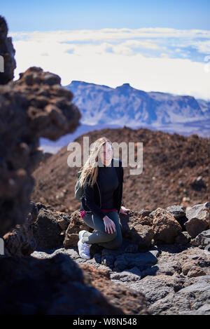 Junge Frau auf dem Gipfel des Teide in Teneriffa, Spanien sitzen Stockfoto