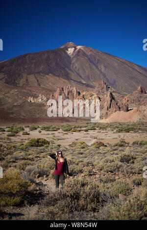 Junge Frau vor Roques de Garcia Bildung mit dem Vulkan Teide im Hintergrund Stockfoto