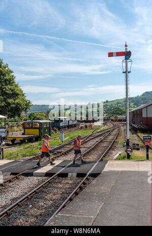 Winchcombe, Gloucestershire, England, UK. August 2019. Freiwillige Überquerung der Bahnstrecke von der Gloucestershire Warwickshire Steam Railway. Stockfoto