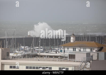 Brighton, UK. 10 Aug, 2019. Starke Winde von bis zu 50 Meilen pro Stunde in Brighton, East Sussex sind Sie Prognose den ganzen Tag fortzusetzen. Wellen gegen die Marina an der Wand und stuerzte in den Hafen als Besucher Fotos der ungewöhnlich hohe Wellen. Credit: Keith Larby/Alamy leben Nachrichten Stockfoto