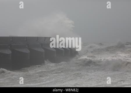 Brighton, UK. 10 Aug, 2019. Starke Winde von bis zu 50 Meilen pro Stunde in Brighton, East Sussex sind Sie Prognose den ganzen Tag fortzusetzen. Wellen gegen die Marina an der Wand und stuerzte in den Hafen als Besucher Fotos der ungewöhnlich hohe Wellen. Credit: Keith Larby/Alamy leben Nachrichten Stockfoto