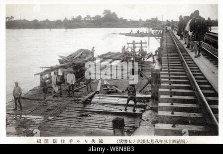 [1910s Japan - Kanto Flut in Tokio, 1910] - Menschen arbeiten auf dem senju Shinkaibashi Brücke (千住新開橋), in, was jetzt Adachi-ku (足立区), Tokyo, während der Flut vom 11. August 1910 (Meiji 43). Dies ist eine Katastrophe, jetzt bekannt als die Kanto Flut (関東大水害, Kanto Dai Suigai). Es ist Tokio dritten schlimmsten Flut Katastrophe des 20. Jahrhunderts. 20. jahrhundert alte Ansichtskarte. Stockfoto