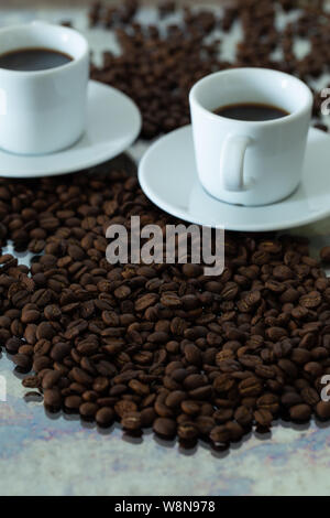 Schwarzen Kaffee in kleinen Tassen. Verschüttete Körner Stockfoto