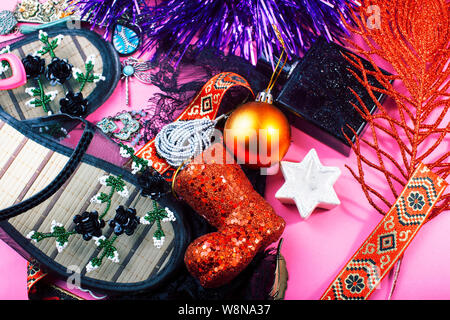 Neues Jahr Partei Material in der Nähe in der Unordnung auf hellen rosa Hintergrund, Weihnachtsgeschenke Konzept Stockfoto
