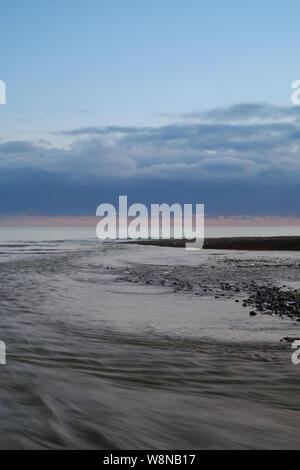 Abfluss aus dem Cuckmere river Mündung auf einem kühlen Blau Abend 1. Stockfoto