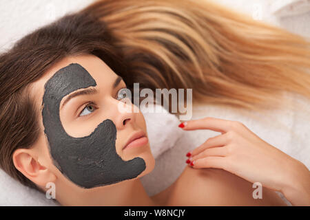 Spa. Hardware Kosmetologie. Closeup Bild der reizende junge Frau mit Creme Maske in einem Schönheitssalon. Stockfoto