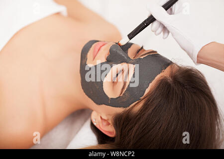 Spa. Hardware Kosmetologie. Closeup Bild der reizende junge Frau mit Creme Maske in einem Schönheitssalon. Stockfoto