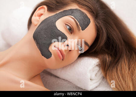 Spa. Hardware Kosmetologie. Closeup Bild der reizende junge Frau mit Creme Maske in einem Schönheitssalon. Stockfoto