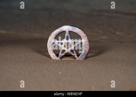 Holz- umkreist Pentagramm Symbol am Strand bei Sonnenaufgang vor dem See. Konzept der Fünf Elemente: Erde, Wasser, Luft, Feuer, Geist. Stockfoto